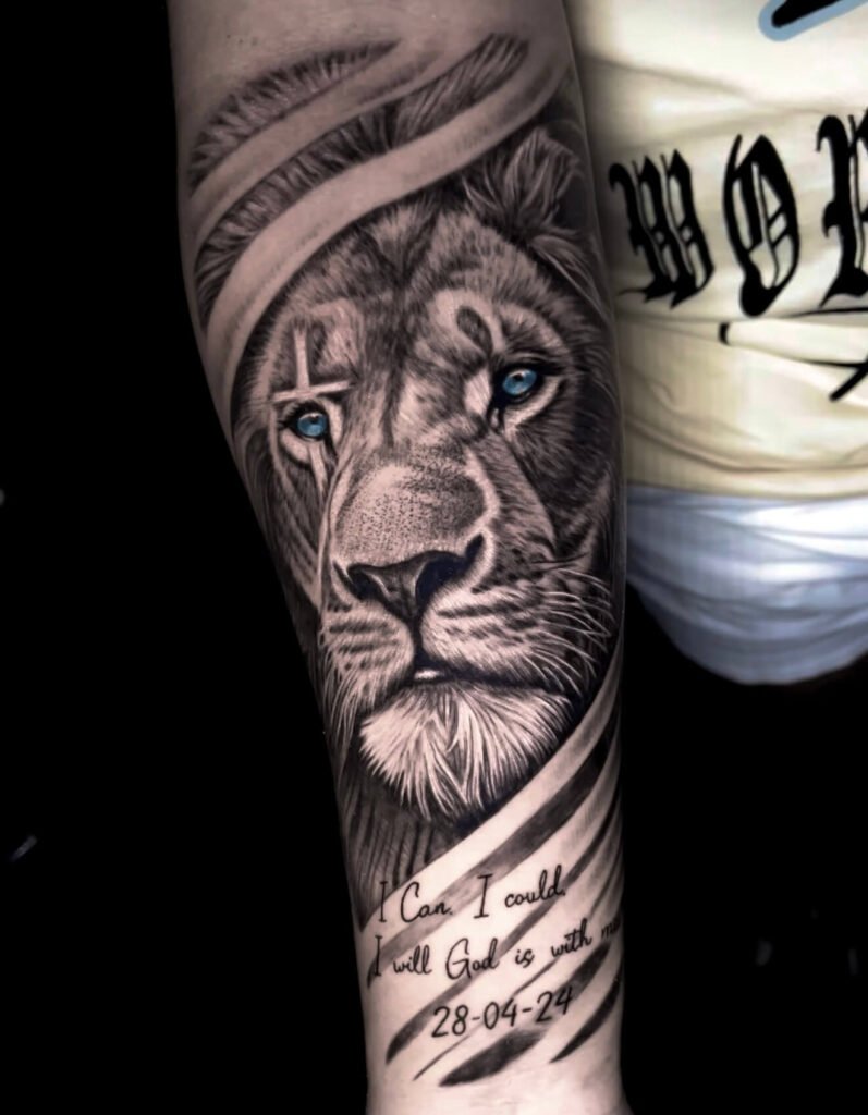 Lion with blue eyes and handwritten script, forearm